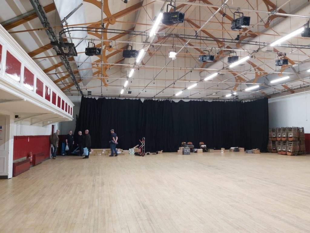 Empty hall with just some boxes left on the floor waiting to be loaded onto vehicles and taken back home. 